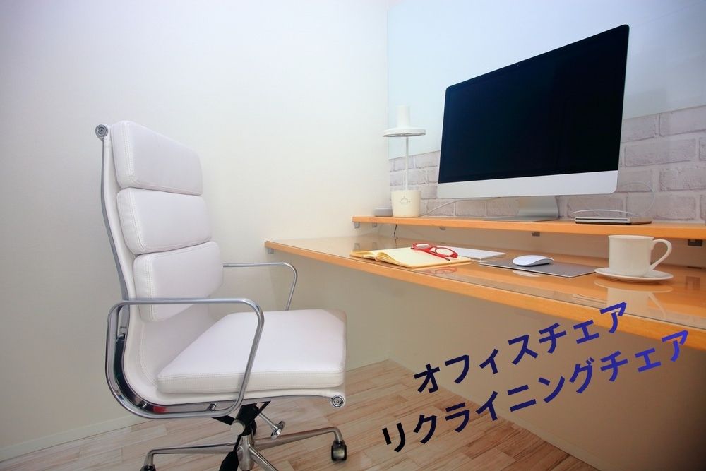 木目調のデスクに置かれたPCと白いオフィスチェアの写真